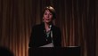 Businesswoman speaking at lectern to raised hands in audience