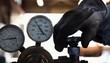 Worker turning on knob next gauges