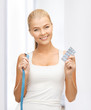 woman with measuring tape and diet pills