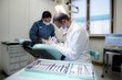 Close-up of dentist tools in clinic with patient lying on couch
