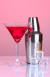 Cocktail shaker and cocktail on red background