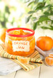 Orange jam with zest and tangerines, on white wooden table