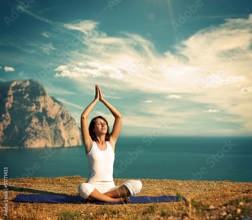 Photo: Woman Doing Yoga at the Sea and Mountains Woman Doing Yoga at the Sea and Mountains
