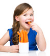 Cute little girl is eating carrot