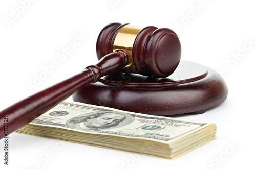 Photo: Law gavel on a stack of American money. Law gavel on a stack of American money.