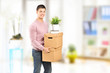 Young man carrying removal boxes in an apartment