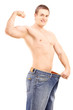 Fit muscular man in a big pair of jeans showing his biceps