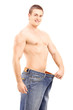 Weight loss muscular man in a big pair of jeans