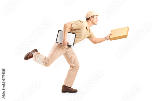 Photo: Full length portrait of a delivery boy in a rush delivering a pa Full length portrait of a delivery boy in a rush delivering a pa
