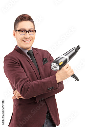 Photo: Smiling male hairdresser holding a blow dryer Smiling male hairdresser holding a blow dryer