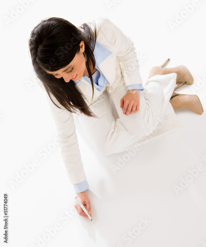 Photo: Business woman writing on the floor Business woman writing on the floor
