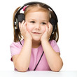 Little girl is enjoying music using headphones
