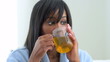 African American woman drinking tea in robe