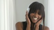 African American woman listening to headphones and smiling