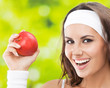 Photo: Woman in fitness wear with apple, outdoors Woman in fitness wear with apple, outdoors