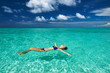 Woman in bikini lying on water