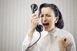Photo: Young Woman shouting into telephone Young Woman shouting into telephone