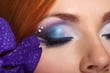 Beautiful female eyes with bright blue make-up and orchid