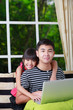 Foto: Little asian girl pointing on laptop with big brother Little asian girl pointing on laptop with big brother