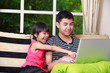 Foto: Little asian girl pointing on laptop with big brother Little asian girl pointing on laptop with big brother