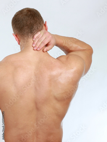 Photo: Muscular man with back neck ache Muscular man with back neck ache