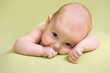 small baby girl lying on green bed
