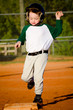 Photo: Young child running bases while playing baseball Young child running bases while playing baseball