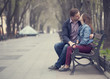 Couple kissing at the bench at alley.