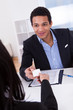 Businesswoman Offering Visiting Card To Man In Office