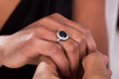 Male Hand Inserting Ring Into A Finger
