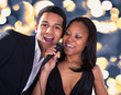 African Couple Singing With Microphone
