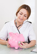 Female Doctor Examining Piggybank