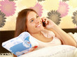 A teenager girl lying on a bed reading a book
