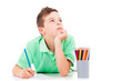 Dreaming boy lying on the floor and drawing with colorful pencil