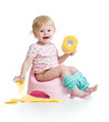 smiling baby sitting on chamber pot with toilet paper roll