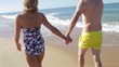Close Up Of Senior Couple Holding Hands Walking Along Beach