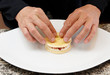 Pastry chef is carefully making a dessert