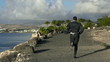 Young businessman jogging on the seashore, slow motion shot 60