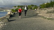 Young woman and businessman jogging on the beach, slow motion sh
