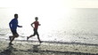 Young couple jogging on the beach, slow motion shot at 240fps 