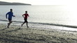 Young couple jogging on the beach, slow motion shot at 240fps 