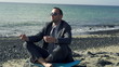 Businessman meditating on a sunny beach in the morning, slow mot