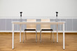 Leeres Podium mit zwei Stühlen und Mikrofonen