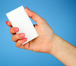 Foto: Female hand holding business card, on color background Female hand holding business card, on color background