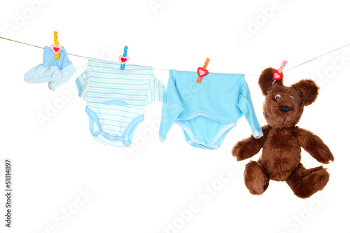 Photo: Baby clothes hanging on clothesline, isolated on white Baby clothes hanging on clothesline, isolated on white
