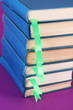 Many books with bookmarks on purple background close-up