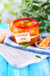 Orange jam with zest and tangerines, on blue wooden table