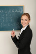 Photo: Portrait of teacher woman near the chalkboard in classroom Portrait of teacher woman near the chalkboard in classroom