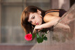 Foto: Sad young woman with a red rose Sad young woman with a red rose