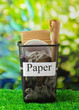 Assorted trash in bucket on nature background